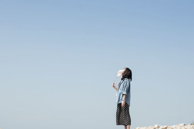 Low angle view of person against clear sky