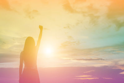 Silhouette woman standing against sky during sunset