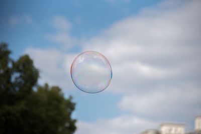 Low angle view of bubbles against rainbow in sky