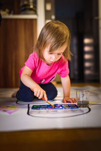 Child painting on the floor