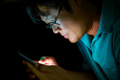 Close-up of man wearing eyeglasses using mobile phone