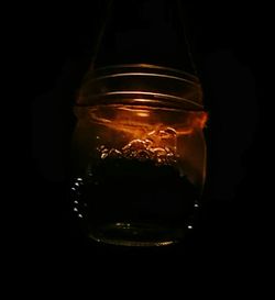 Close-up of lit candle against black background