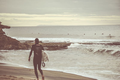 Rear view of man walking on beach