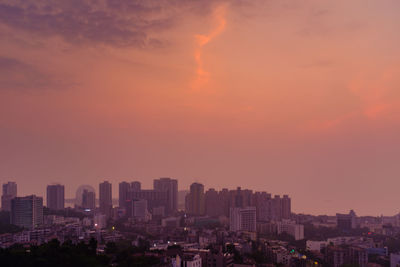 Aerial view of buildings in city against sky during sunset