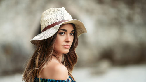 Close-up portrait of beautiful young woman wearing hat