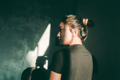 Rear view of young woman against wall