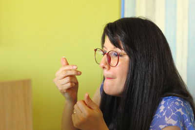 Portrait of young woman holding eyeglasses