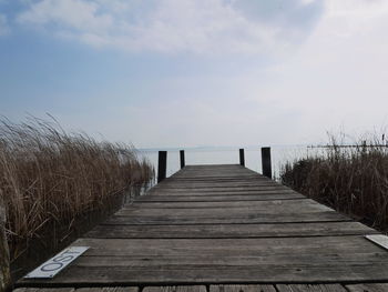 View of wooden pier over sea against sky