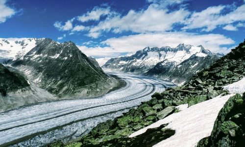 Scenic view of road by mountains against sky