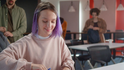 Portrait of young woman using mobile phone in cafe