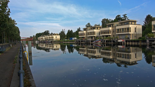 Buildings by lake against sky in city