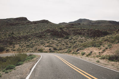 Road amidst mountains against clear sky