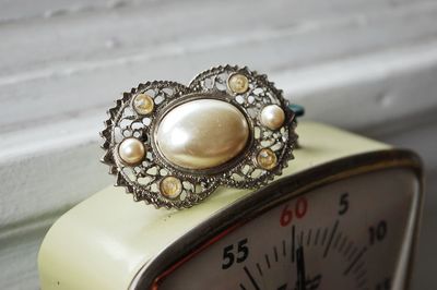 Close-up of jewelry on clock at table