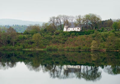 Scenic view of lake by trees against sky