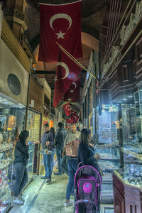 Rear view of people walking on illuminated street