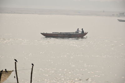 Fishing boat in sea against sky