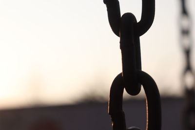 Close-up of silhouette chain against sky during sunset