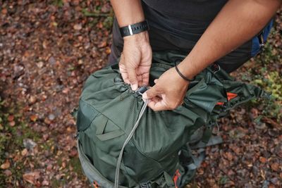 High angle view of man opening backpack on field