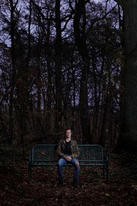 Man sits  on bench in the wood 