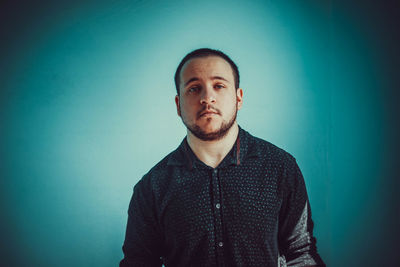 Portrait of young man against blue background