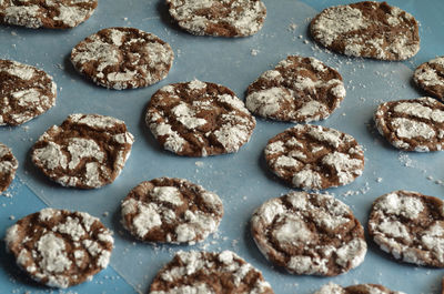 Homemade chocolate crinkle cookies on blue paper