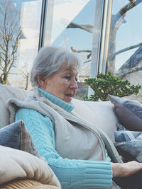 Portrait of woman sitting on sofa at home