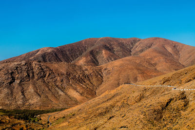 Scenic view of rocky mountains against clear blue sky