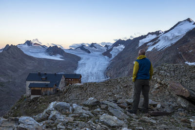 Rear view of woman standing on snow covered mountain