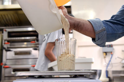 Cropped hand of man preparing food in commercial kitchen