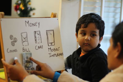 Mother teaching home finance to child at home