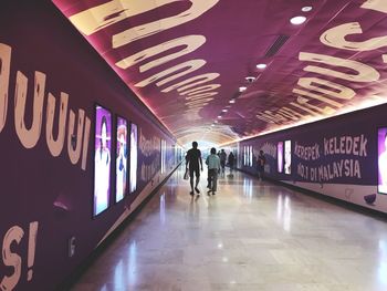 Man walking in illuminated underground walkway