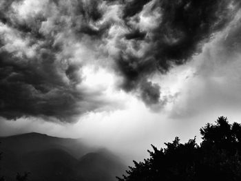 Low angle view of storm clouds over mountain