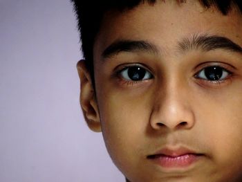 Close-up portrait of boy against purple background