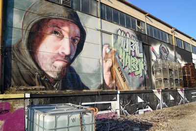 Portrait of man standing against graffiti wall