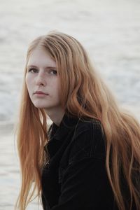 Portrait of beautiful young woman against sea