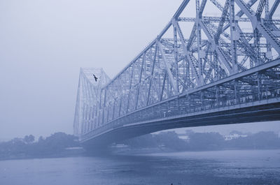 Low angle view of bridge over river against sky