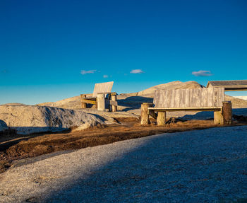 View of benches against clear blue sky