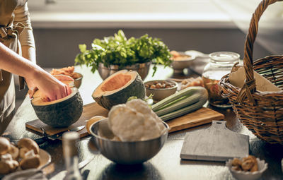 Cropped hand of person preparing food on table