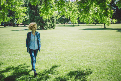 Rear view of woman walking on grassland