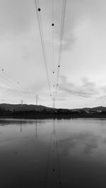 Birds over lake against sky