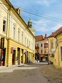 Street amidst buildings in town against sky