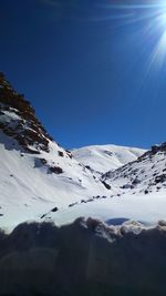 Scenic view of snowcapped mountains against clear blue sky