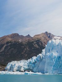 Scenic view of snowcapped mountains by sea against sky