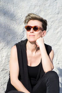 Portrait of young woman sitting in sunglasses