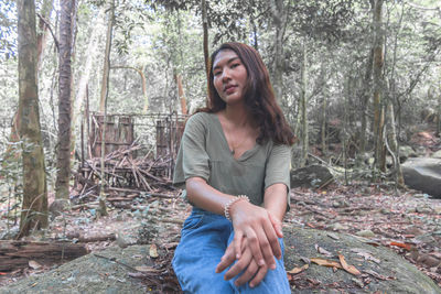 Portrait of woman sitting in forest