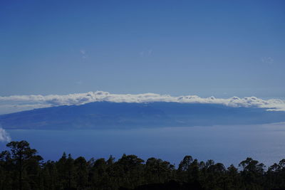 Scenic view of mountains against blue sky