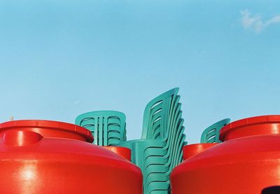 Low angle view of empty chairs against clear blue sky