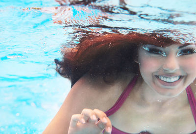 Portrait of a smiling young woman swimming in pool