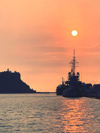 Silhouette ship in sea against sky during sunset