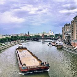 Boats in river with city in background